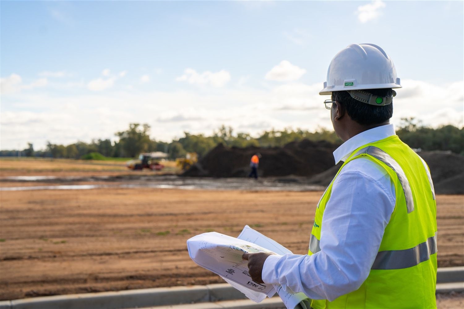 Man with hard hat overseeing construction site