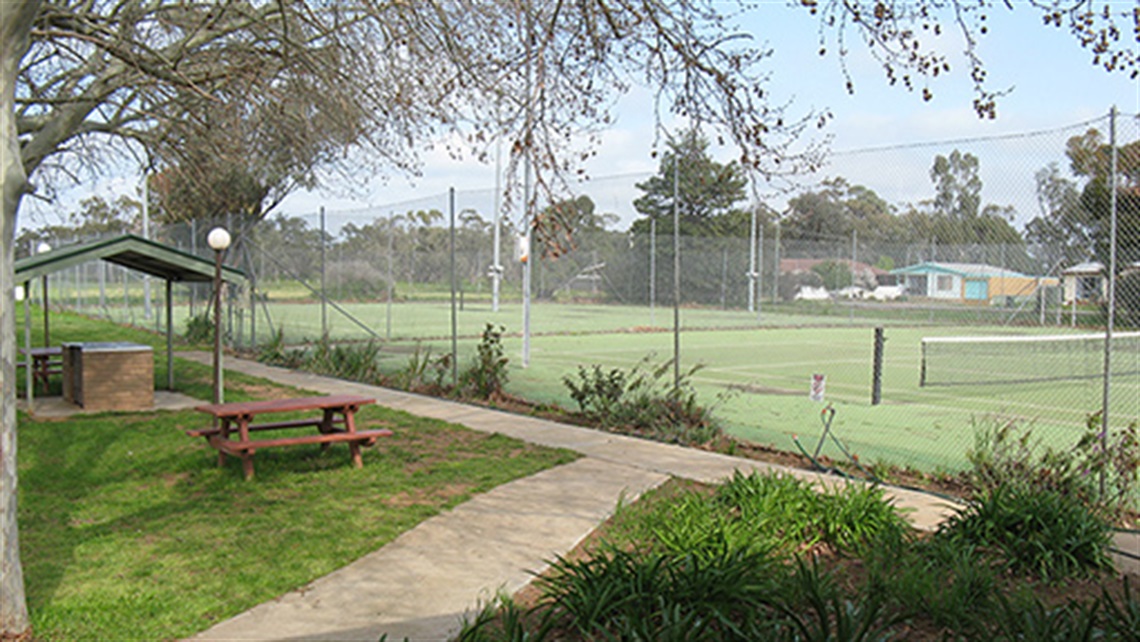 picnic tables and BBQ infront of tennis courts