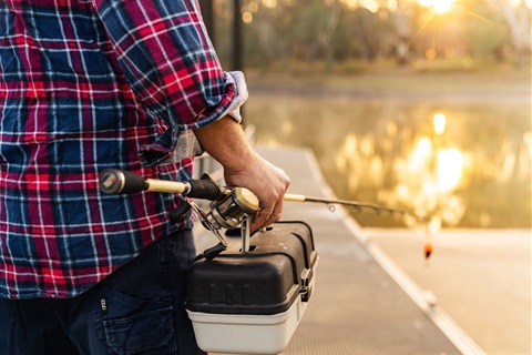 Man with tackle box and rod